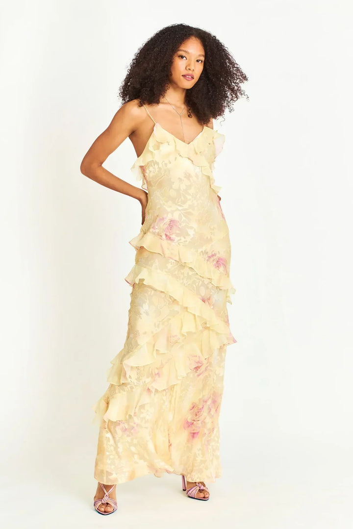 "Robe longue jaune à volants superposés, col en V et imprimé floral, idéale pour occasions spéciales et sorties estivales."