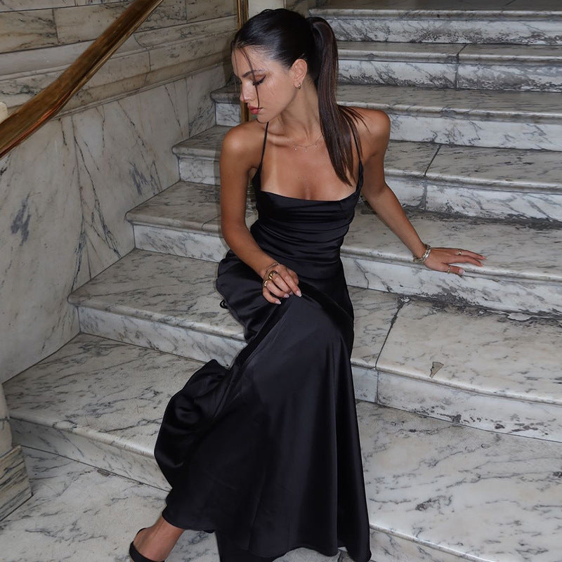 Robe longue satinée noire dos nu élégante, coupe fluide, satin luxueux, lacets croisés, style soirée sophistiqué.