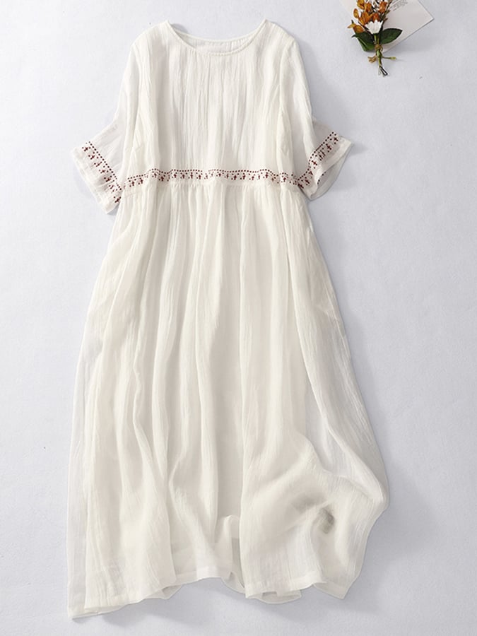 Robe maxi femme brodée de motifs délicats, offrant un look élégant et fluide pour l'été.