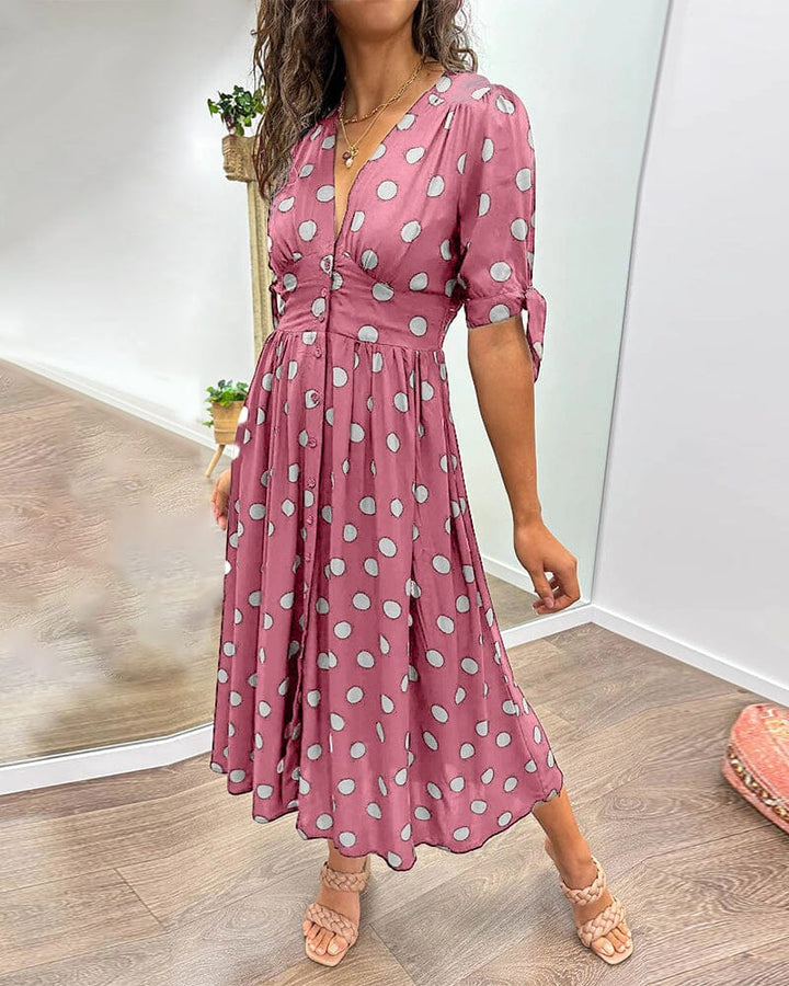 "Robe mi-longue à pois, manches nouées, coupe cintrée, imprimé rétro, parfaite pour occasions élégantes."