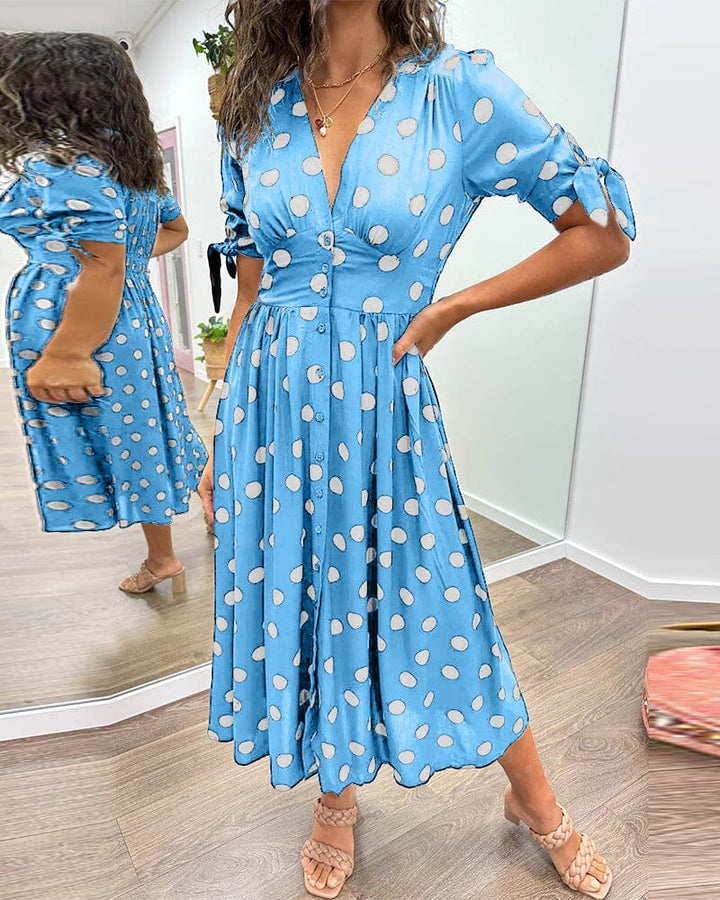 "Robe mi-longue à pois, manches nouées, coupe cintrée, imprimé rétro, parfaite pour occasions élégantes."