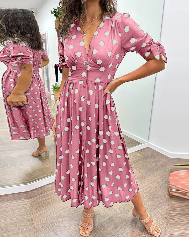"Robe mi-longue à pois, manches nouées, coupe cintrée, imprimé rétro, parfaite pour occasions élégantes."