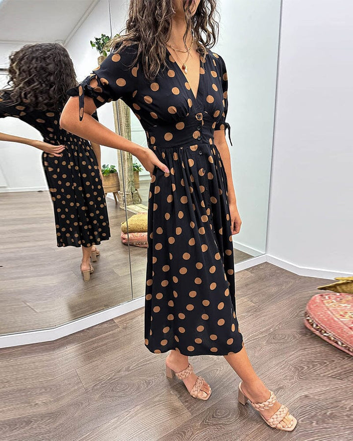 "Robe mi-longue à pois, manches nouées, coupe cintrée, imprimé rétro, parfaite pour occasions élégantes."