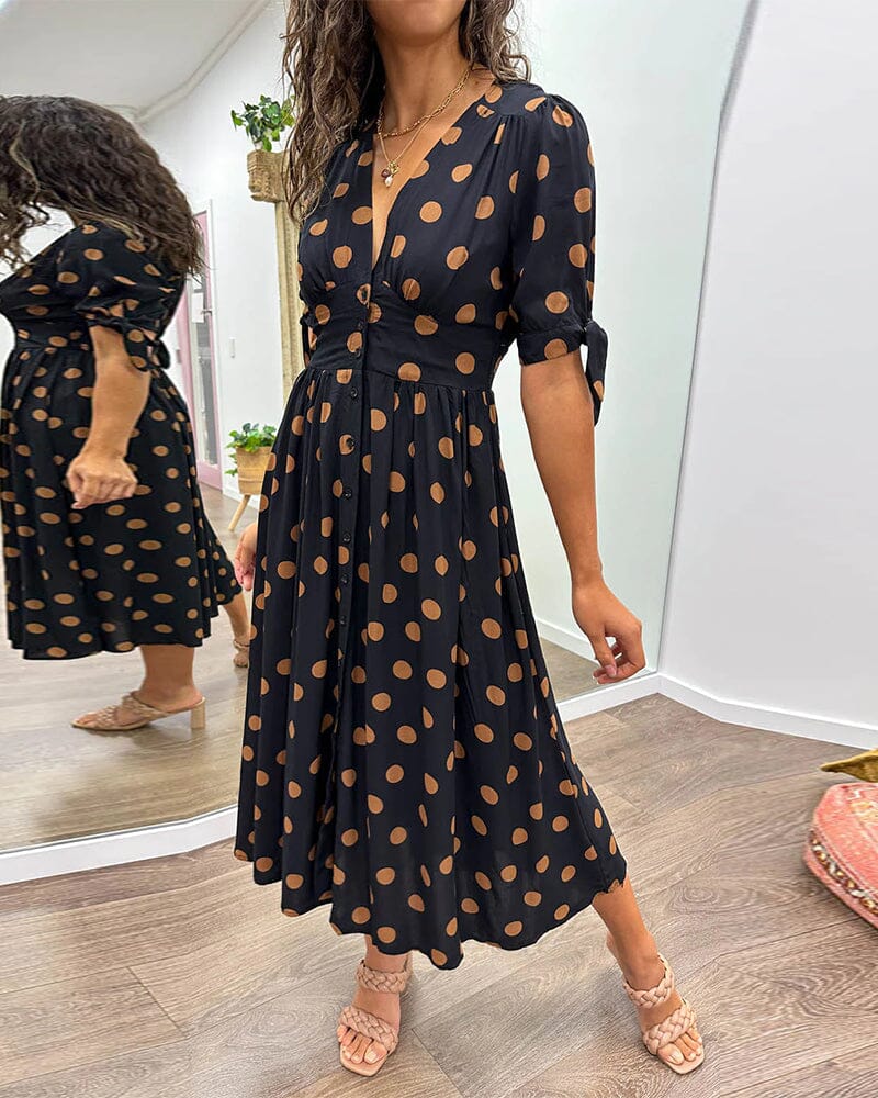 "Robe mi-longue à pois, manches nouées, coupe cintrée, imprimé rétro, parfaite pour occasions élégantes."
