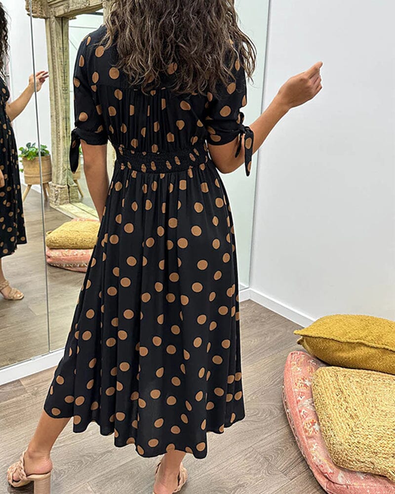 "Robe mi-longue à pois, manches nouées, coupe cintrée, imprimé rétro, parfaite pour occasions élégantes."