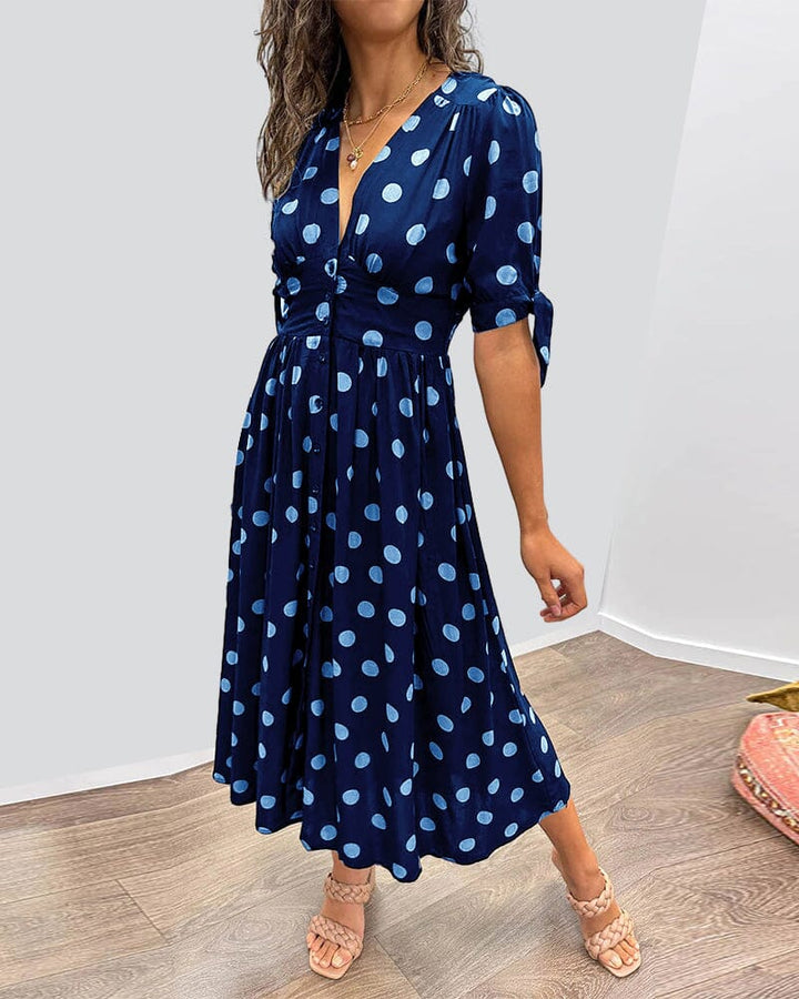 "Robe mi-longue à pois, manches nouées, coupe cintrée, imprimé rétro, parfaite pour occasions élégantes."