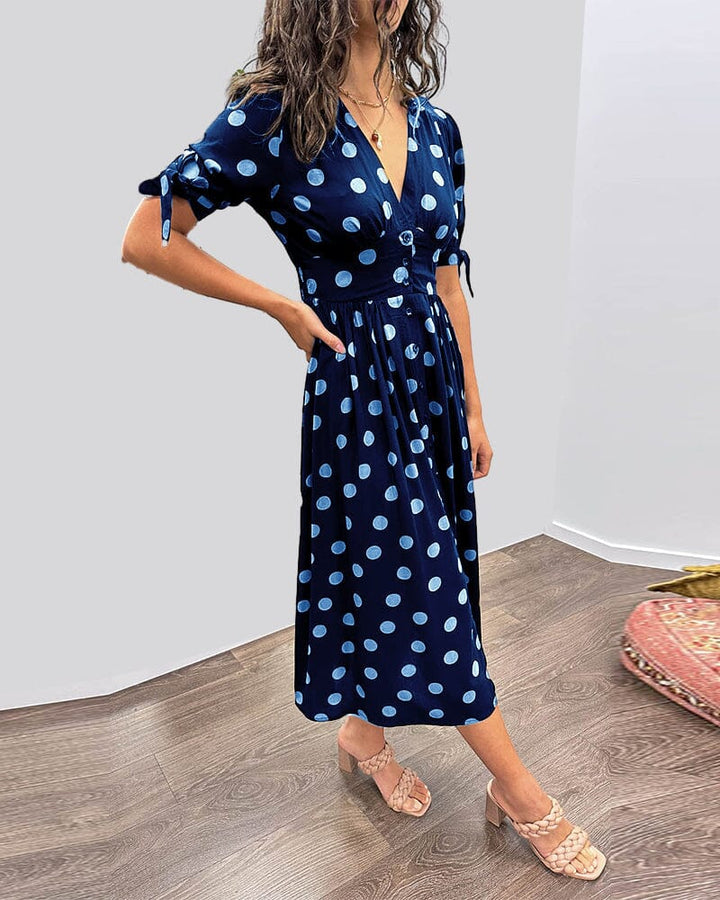 "Robe mi-longue à pois, manches nouées, coupe cintrée, imprimé rétro, parfaite pour occasions élégantes."