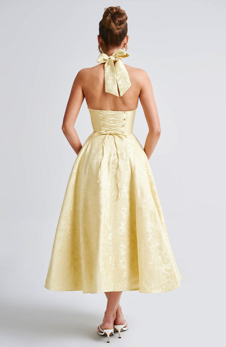 "Robe midi élégante, dos-nu, couleur ivoire, coupe évasée, tissu jacquard floral, idéale pour occasions spéciales."