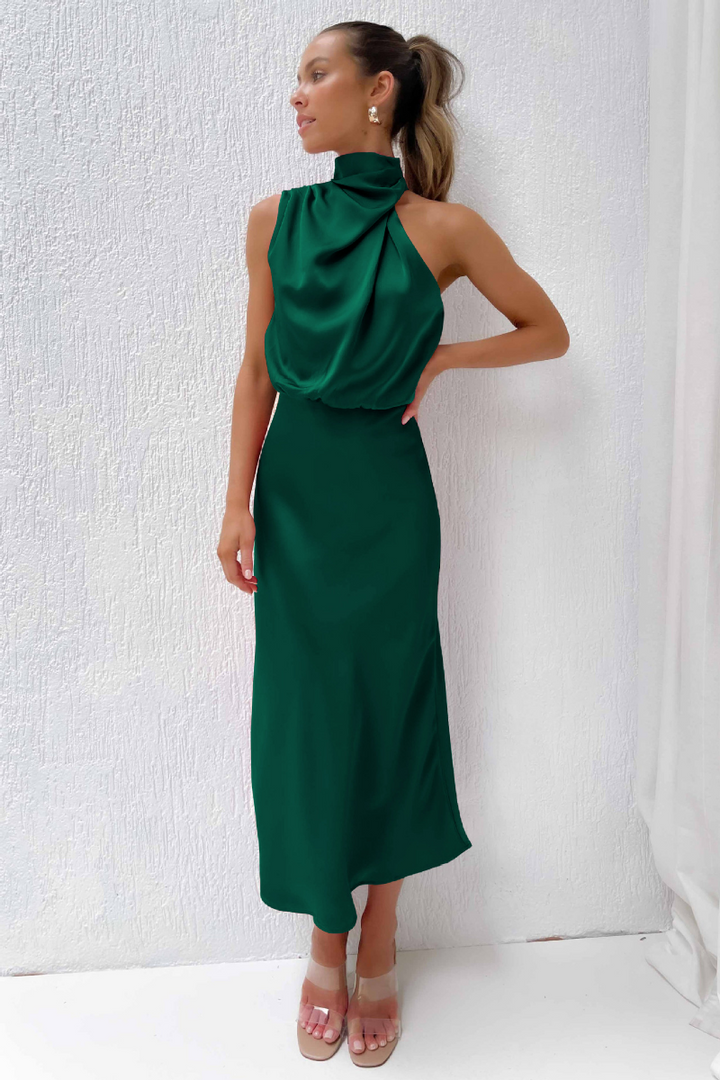 Mannequin portant une robe midi femme élégante, col asymétrique, pour soirée cocktail estivale.