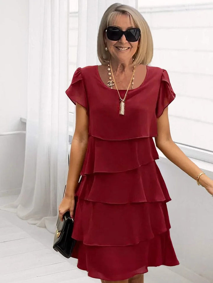 Robe midi femme asymétrique à manches courtes, fluide et superposée. Idéale pour soirée ou cérémonie.