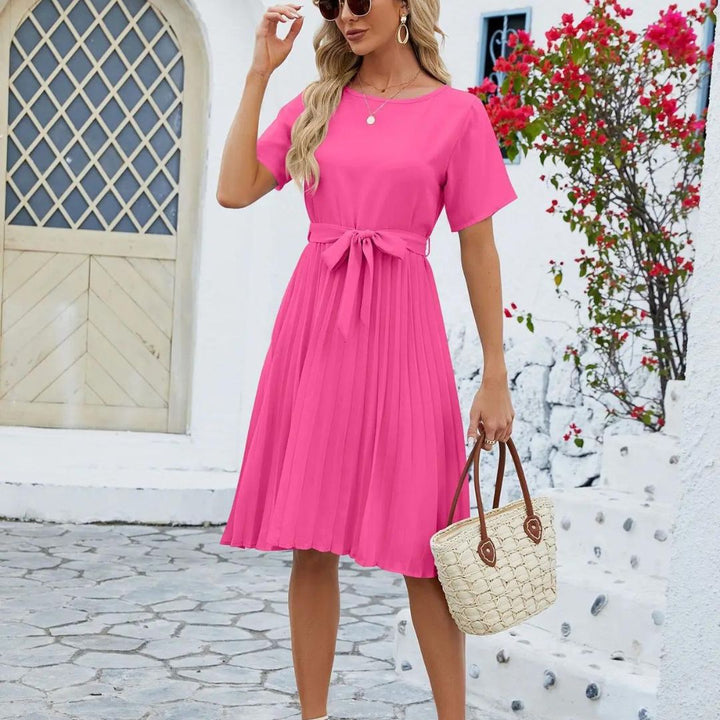 Tenue de bureau chic: robe midi plissée femme avec ceinture à nouer, élégance intemporelle.