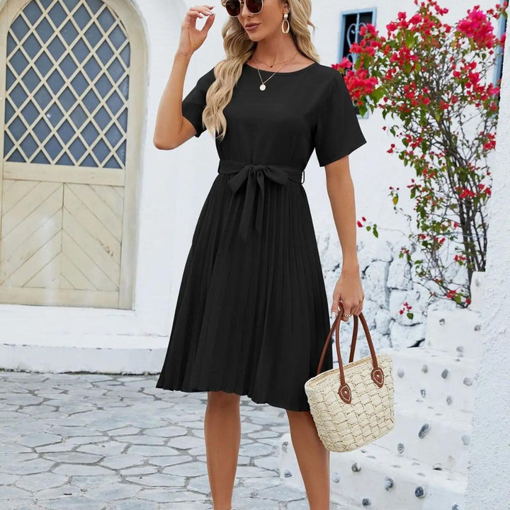 Robe plissée midi femme rose, élégante et moderne, avec ceinture, tenue de bureau stylée.