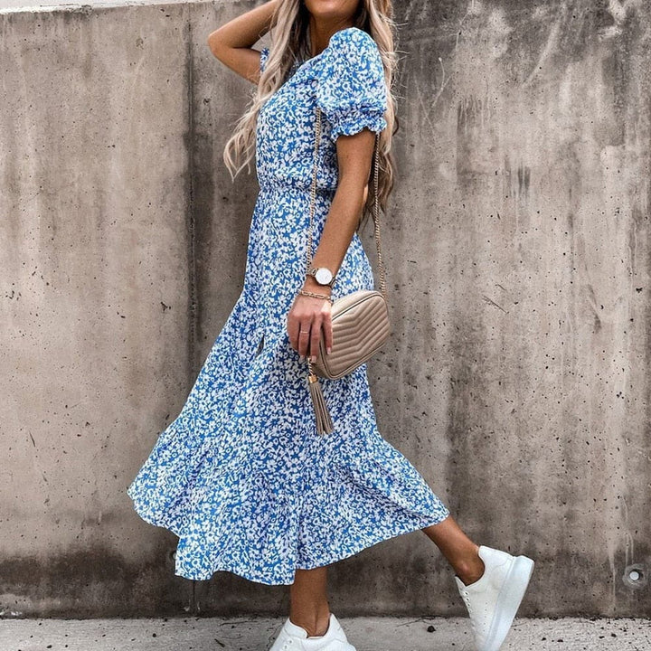 "Robe midi portefeuille rouge en coton avec motif tropical blanc, décolleté en V, manches courtes, silhouette enveloppante."