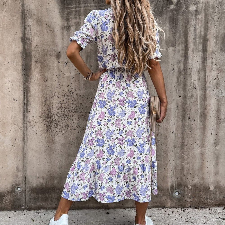 "Robe midi portefeuille rouge en coton avec motif tropical blanc, décolleté en V, manches courtes, silhouette enveloppante."