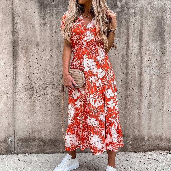 "Robe midi portefeuille rouge en coton avec motif tropical blanc, décolleté en V, manches courtes, silhouette enveloppante."