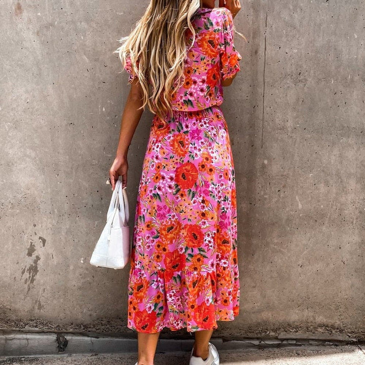 "Robe midi portefeuille rouge en coton avec motif tropical blanc, décolleté en V, manches courtes, silhouette enveloppante."