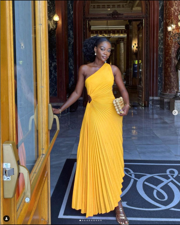 "Robe Regina longue, élégante, aux couleurs vibrantes, en tissu satiné, mettant en valeur la silhouette féminine."