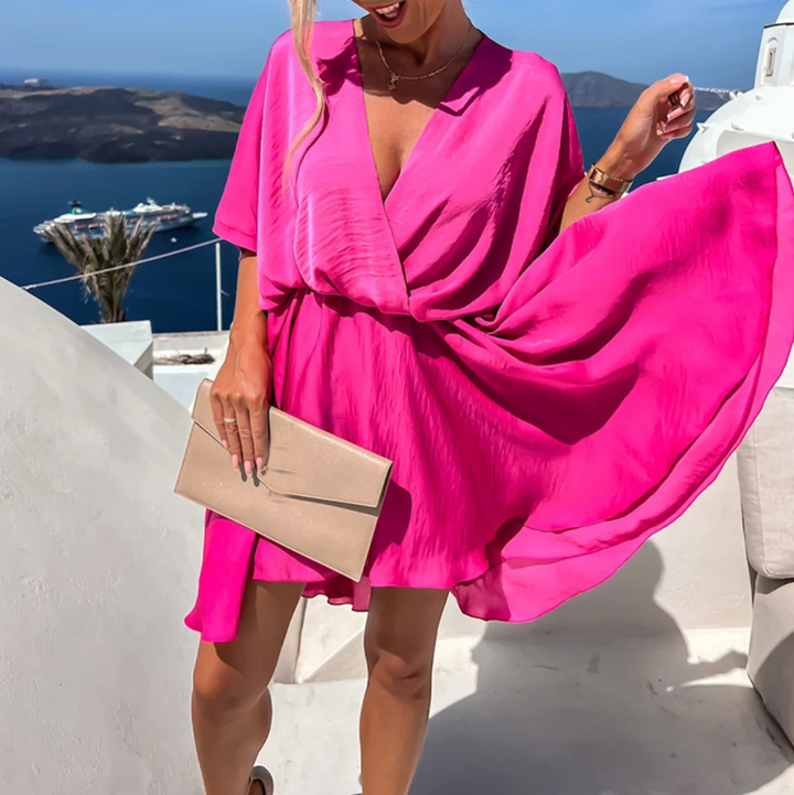 Femme portant une robe rose élégante, coupe flatteuse. Style chic et polyvalent pour toutes.
