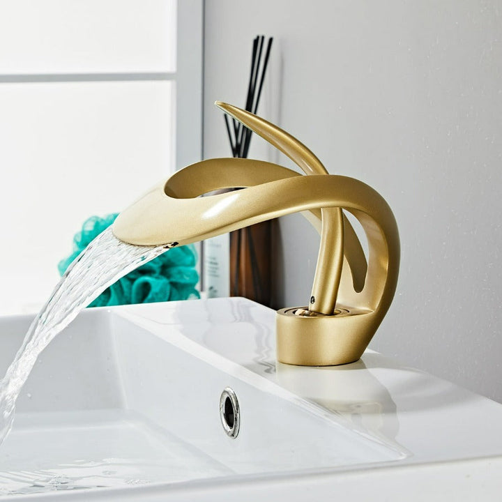 Robinet cascade doré brossé pour salle de bain. Design moderne et luxueux.