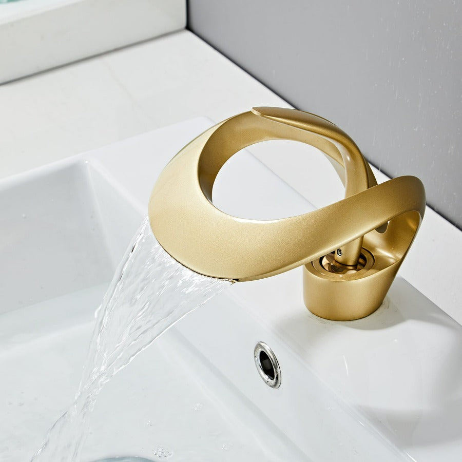 Robinet cascade doré brossé pour salle de bain. Design moderne et luxueux.