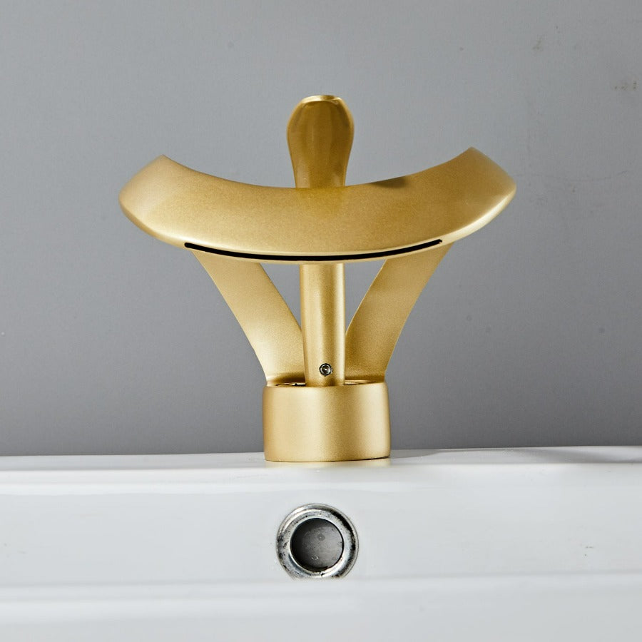 Robinet cascade doré brossé pour salle de bain. Design moderne et luxueux.