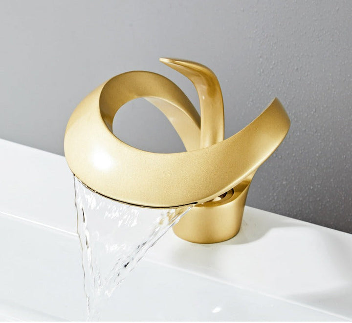 Robinet cascade doré brossé pour salle de bain. Design moderne et luxueux.