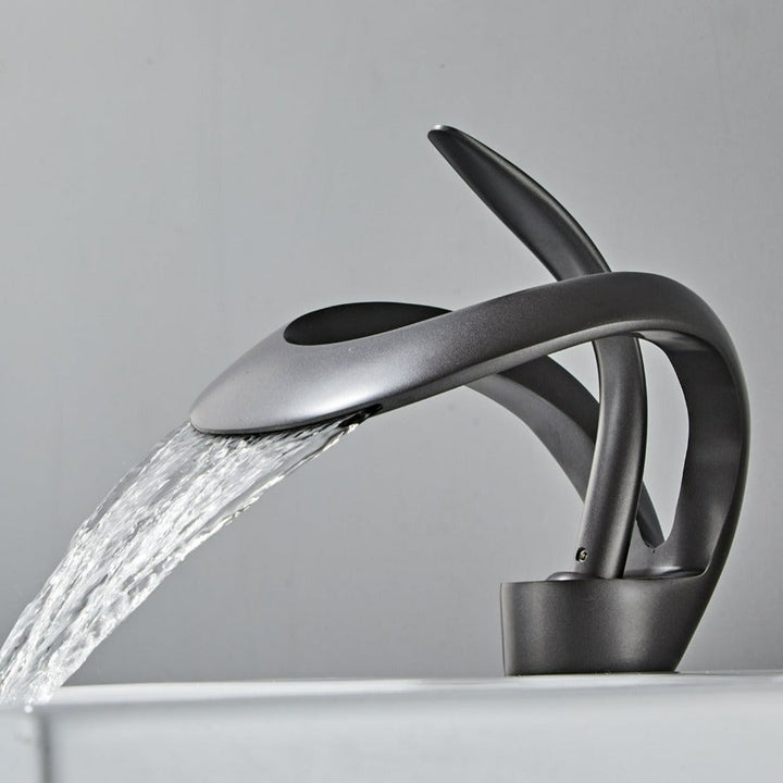 Robinet cascade doré brossé pour salle de bain. Design moderne et luxueux.