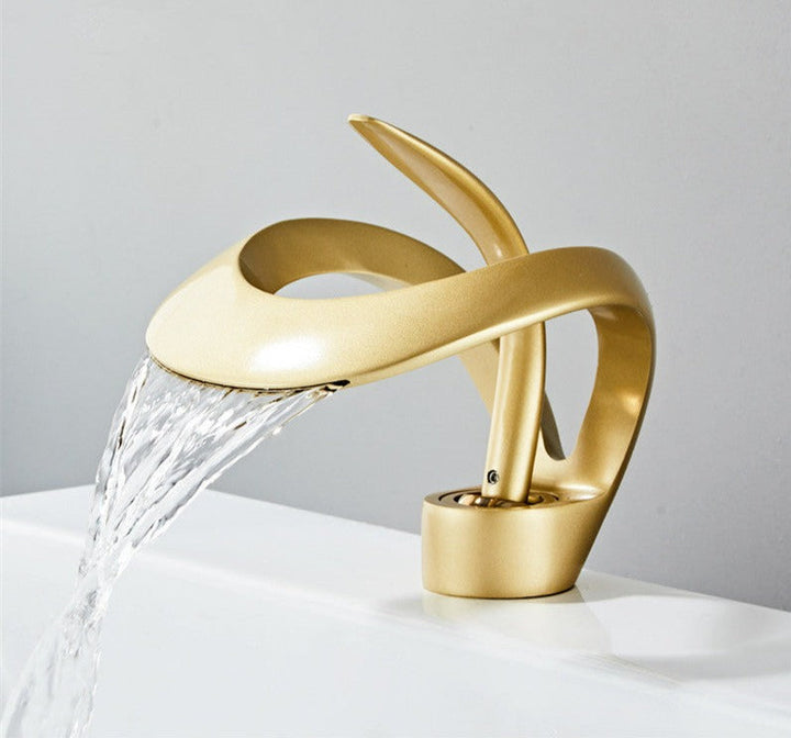 Robinet cascade doré brossé pour salle de bain. Design moderne et luxueux.