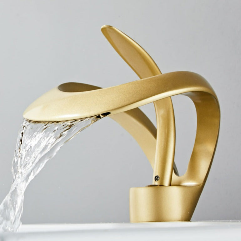 Robinet cascade doré brossé pour salle de bain. Design moderne et luxueux.