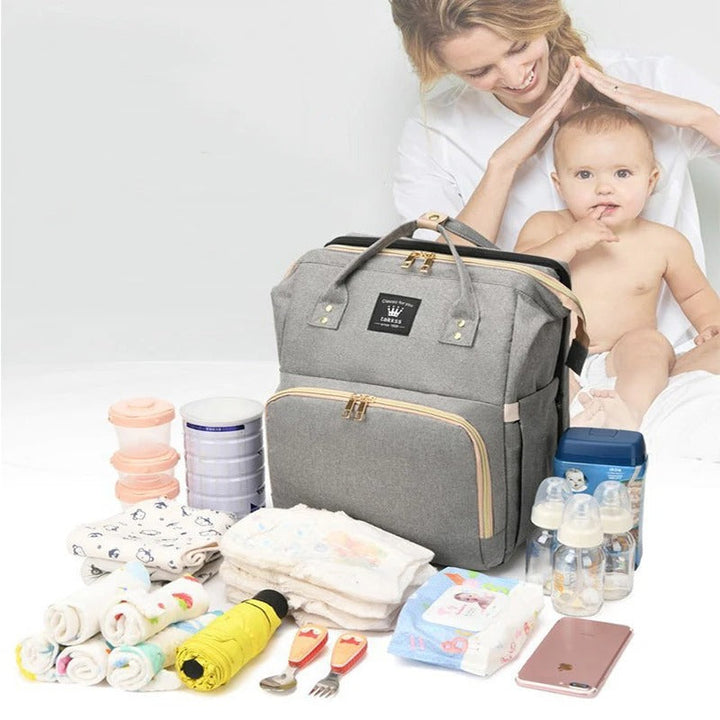 "Sac à langer 3 en 1 élégant et ergonomique avec lit intégré, bretelles ajustables, et compartiments multiples, coloris gris.