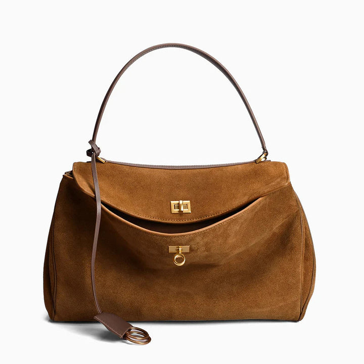 "Sac à main AMÉLIE en daim véritable, automne-hiver, élégant avec fermeture dorée et bandoulière réglable."