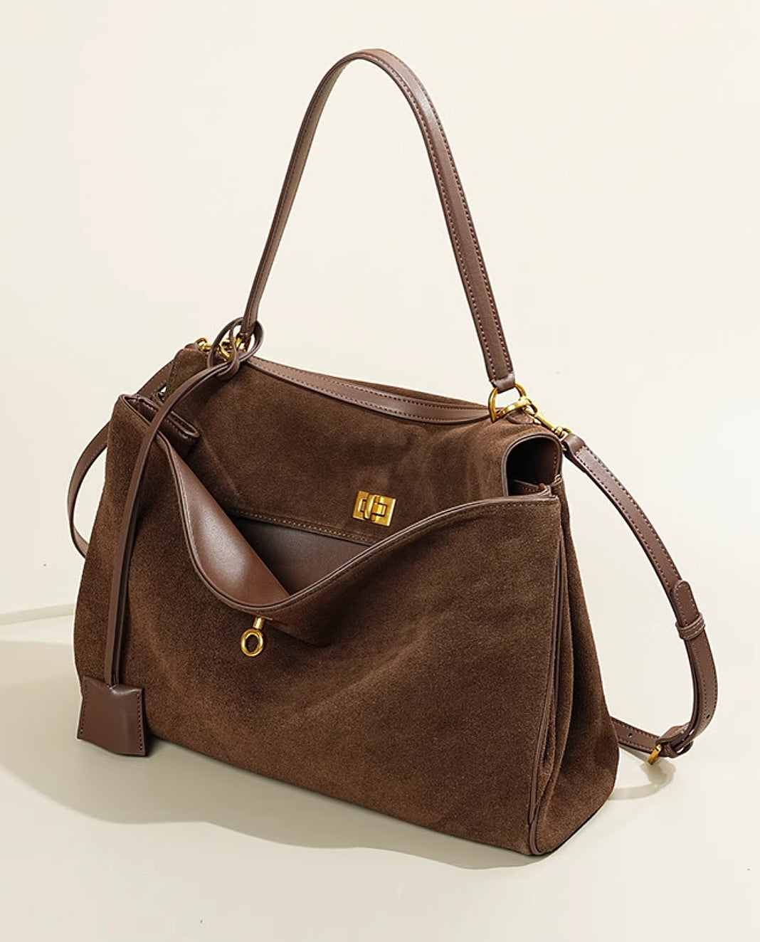 "Sac à main AMÉLIE en daim véritable, automne-hiver, élégant avec fermeture dorée et bandoulière réglable."
