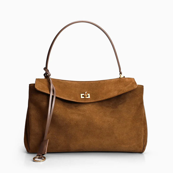 "Sac à main AMÉLIE en daim véritable, automne-hiver, élégant avec fermeture dorée et bandoulière réglable."