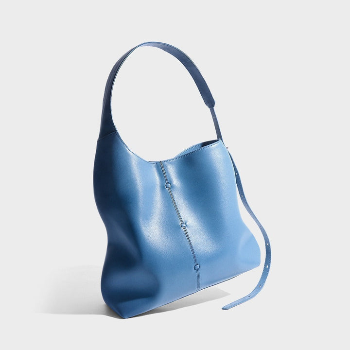 Sac à main femme élégant en cuir bleu foncé, minimaliste et urbain, dimensions 35x26x12 cm avec bandoulière ajustable.