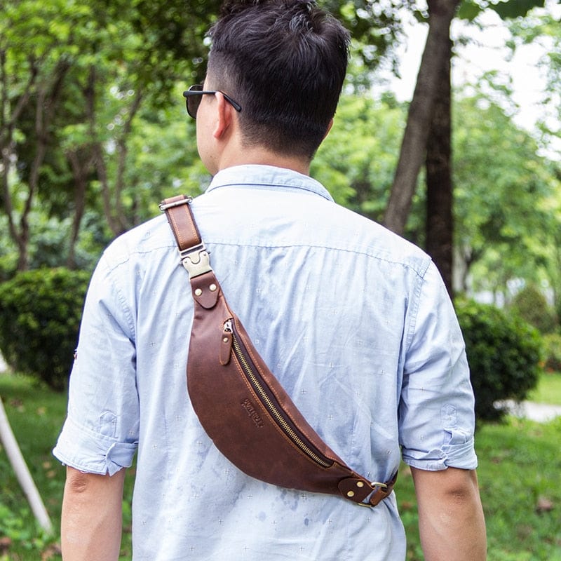 Vue arrière d'un homme portant un sac banane en cuir noir stylé, accessoire de mode masculine moderne et fonctionnel.