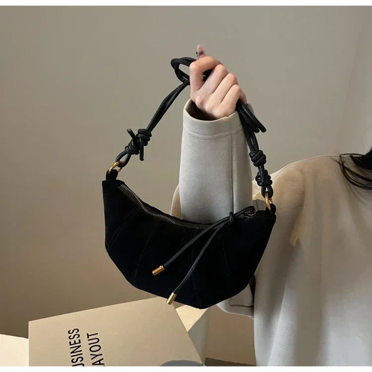 Sac banane noir en suédine pour femme, accessoire de mode élégant et pratique pour toutes occasions.