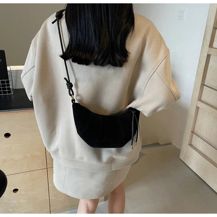 Sac à main banane femme en suédine, design moderne et chic, parfait pour transporter l'essentiel avec style.