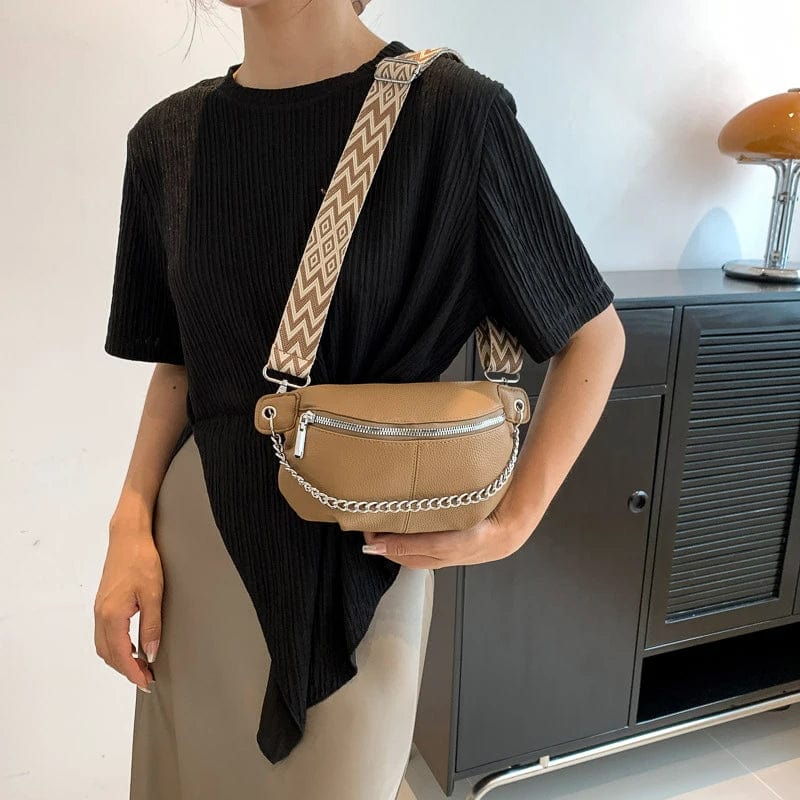 Gros plan sur la fermeture éclair et les surpiqûres d'un sac banane en cuir souple marron pour femme.