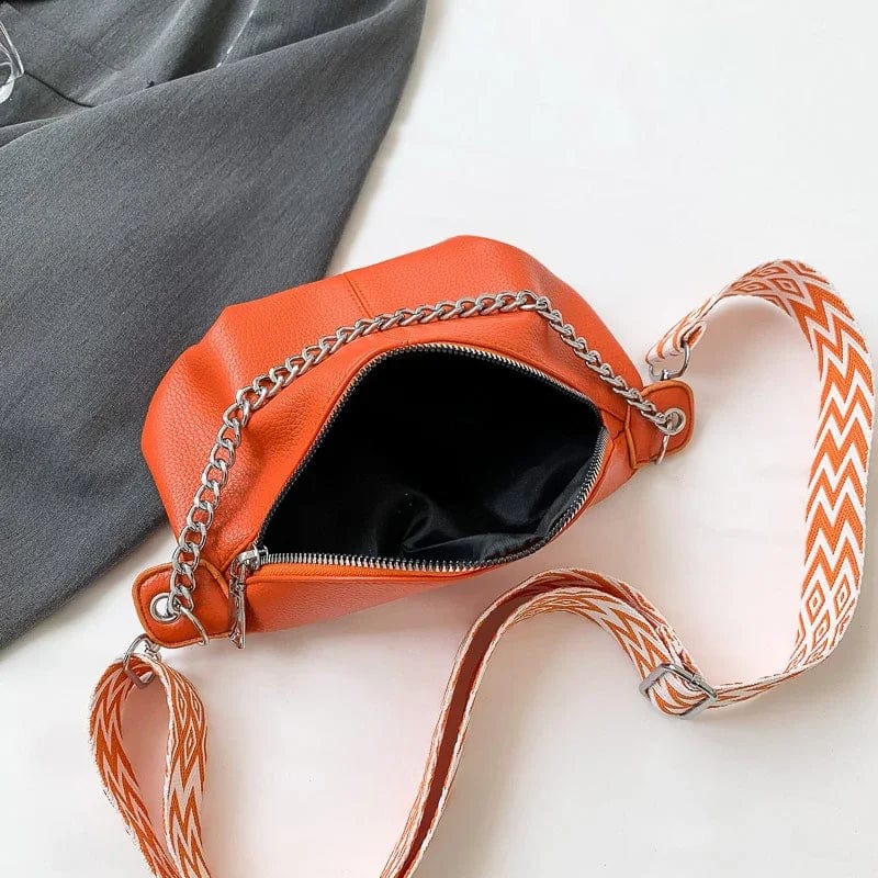 Composition d'accessoires mode: sac banane femme en cuir souple noir, lunettes de soleil et portefeuille.