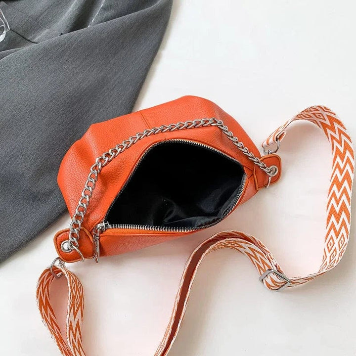 Composition d'accessoires mode: sac banane femme en cuir souple noir, lunettes de soleil et portefeuille.