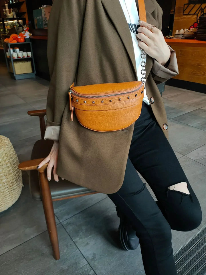 Sac banane femme en cuir noir, porté en bandoulière, accessoire compact et pratique pour le quotidien.