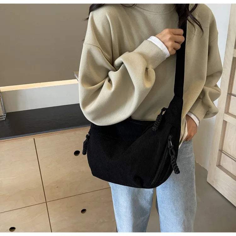 Gros plan d'un sac banane femme en velours côtelé rose, texture douce et élégante