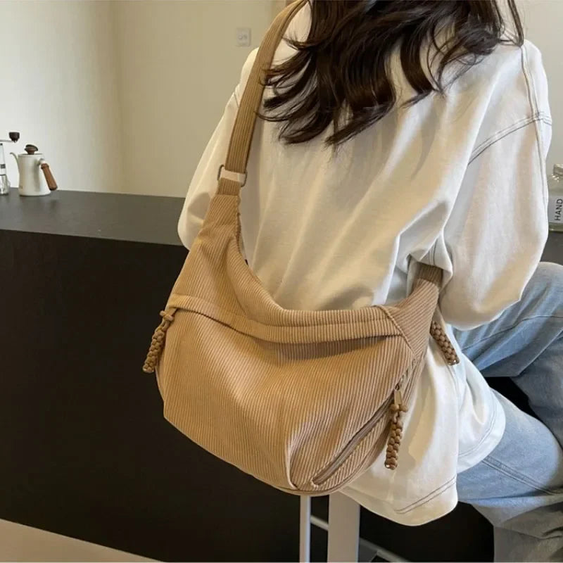 Sac banane femme en velours côtelé noir porté sur une tenue décontractée