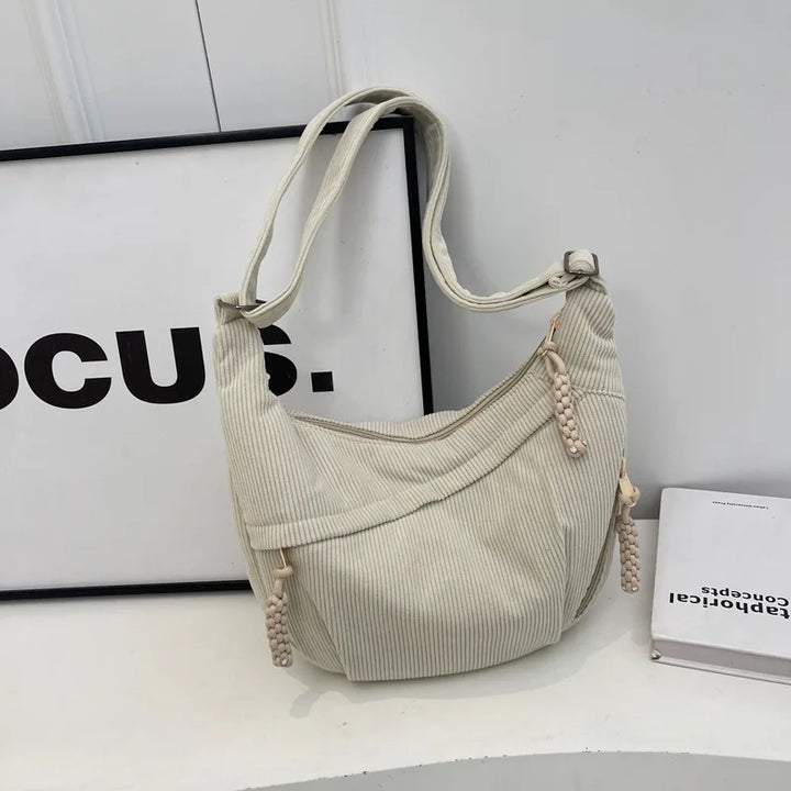 Vue de dos d'un sac banane femme en velours côtelé gris clair, tendance et chic