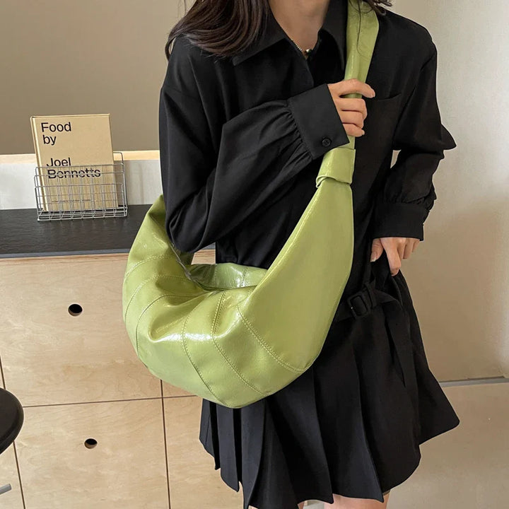 Femme portant un grand sac banane en similicuir, confort et chic au quotidien.