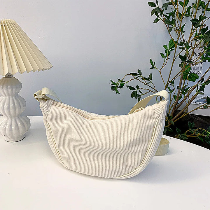 Gros plan sur sac banane femme en velours côtelé, texture douce et chic, un accessoire mode incontournable.
