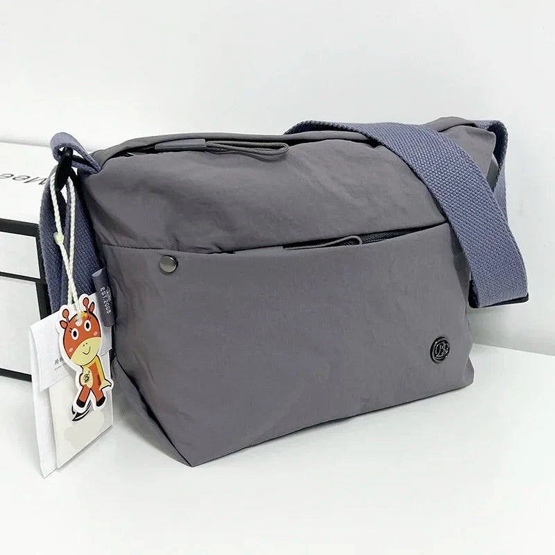 Détail du sac banane femme en nylon léger et imperméable. Montre les poches zippées et la sangle ajustable.