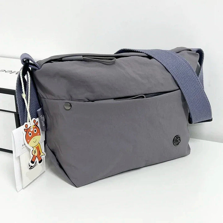 Détail du sac banane femme en nylon léger et imperméable. Montre les poches zippées et la sangle ajustable.