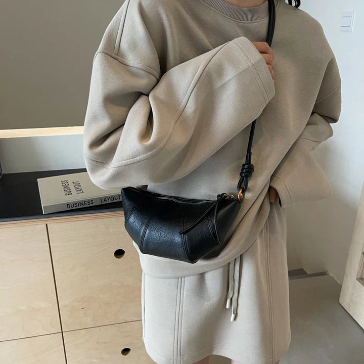 Sac banane femme noir élégant en similicuir, style chic et pratique.