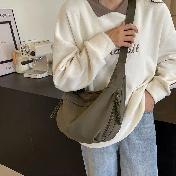 Accessoire mode femme: sac banane bandoulière surdimensionné avec poches zippées.